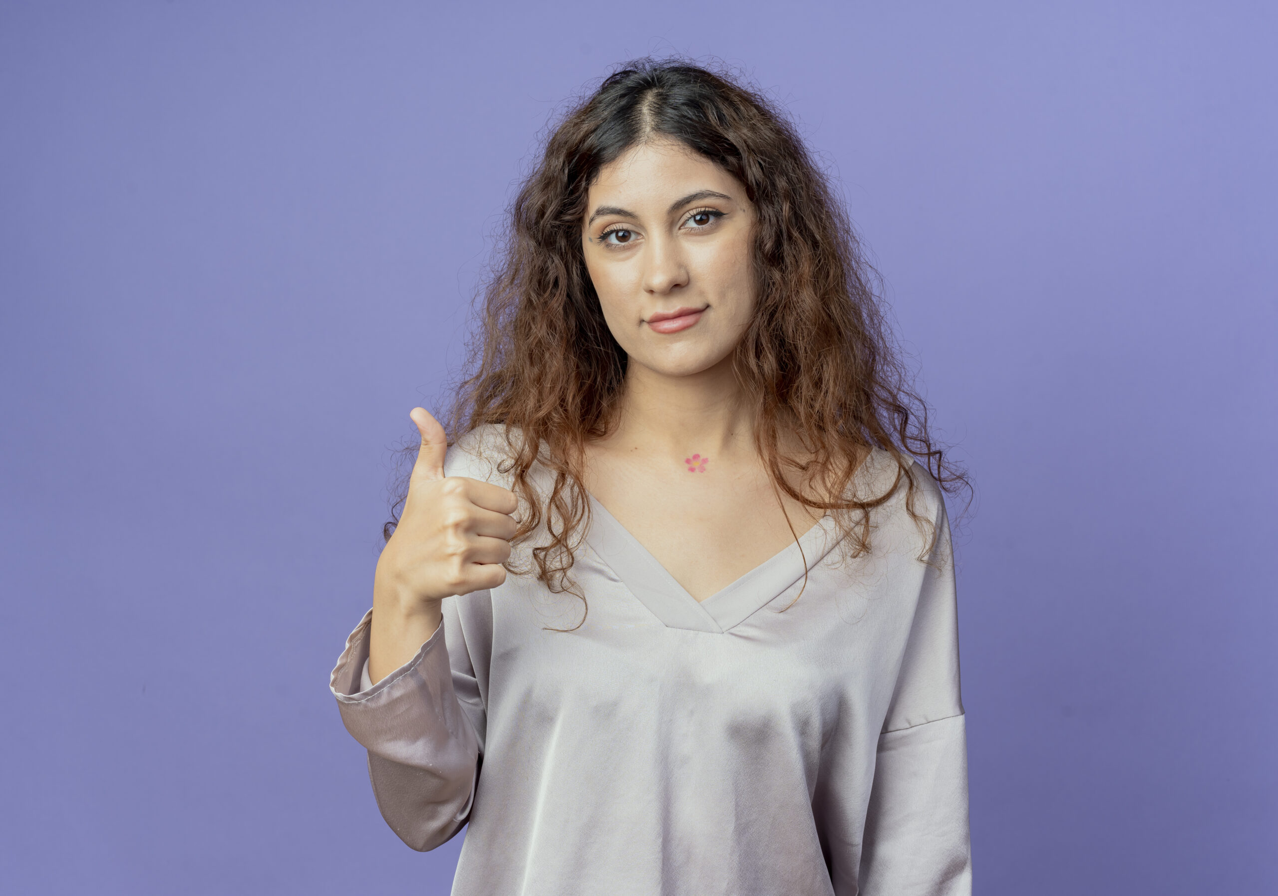 looking at camera young pretty girl her thumb up isolated on blue background
